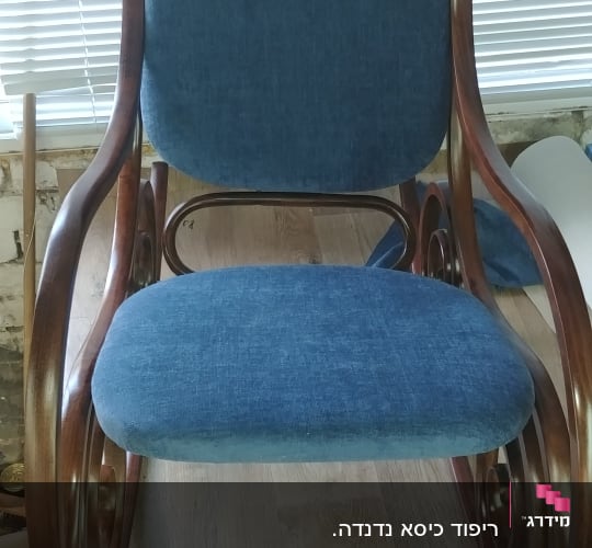 כיסא נדנדה עם ריפוד כחול על מושב ומשענת